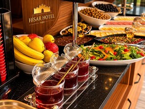 Montaje de bufé con diversas opciones de comida y una estación de bebidas en un hotel.