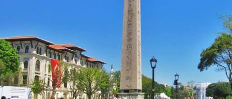 Un grand obélisque, monument situé sur une place publique, entouré de personnes.