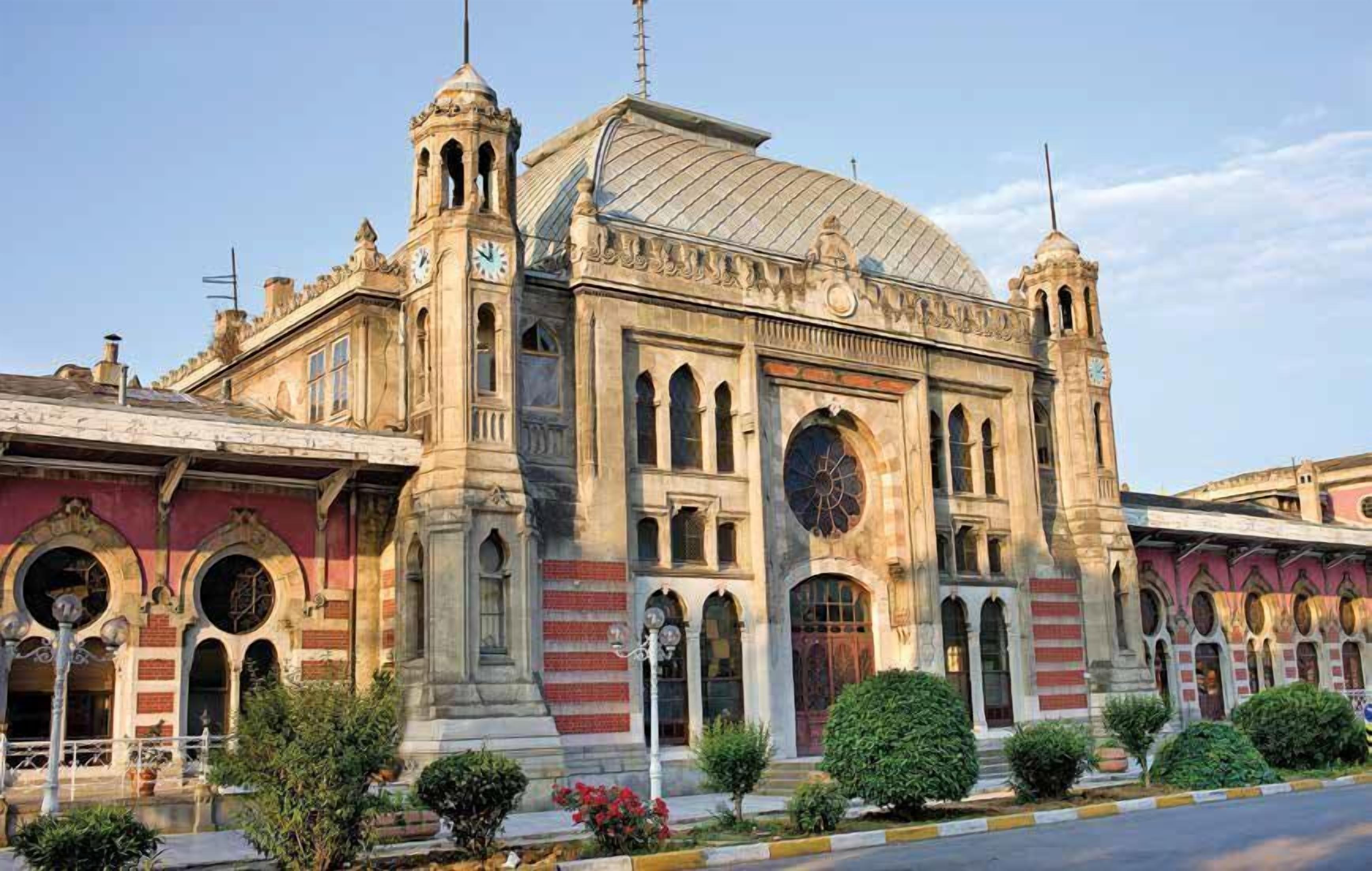 A historic building with a large dome, arched windows, and two clock towers.