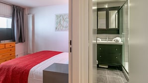 A bedroom with a bed, a dresser, a television, and a window with curtains. - Cozy 3-Room Ski-In Apartment for 6 in La Daille, Val d'Isère with Balcony and Parking (Val-d'Isère)