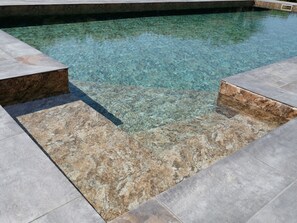 Una piscina cristalina con borde de piedra.