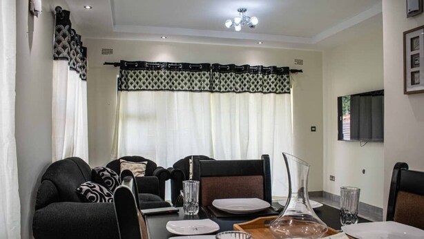 A dining area with a table set for four, including plates, glasses, and a decorative tray.