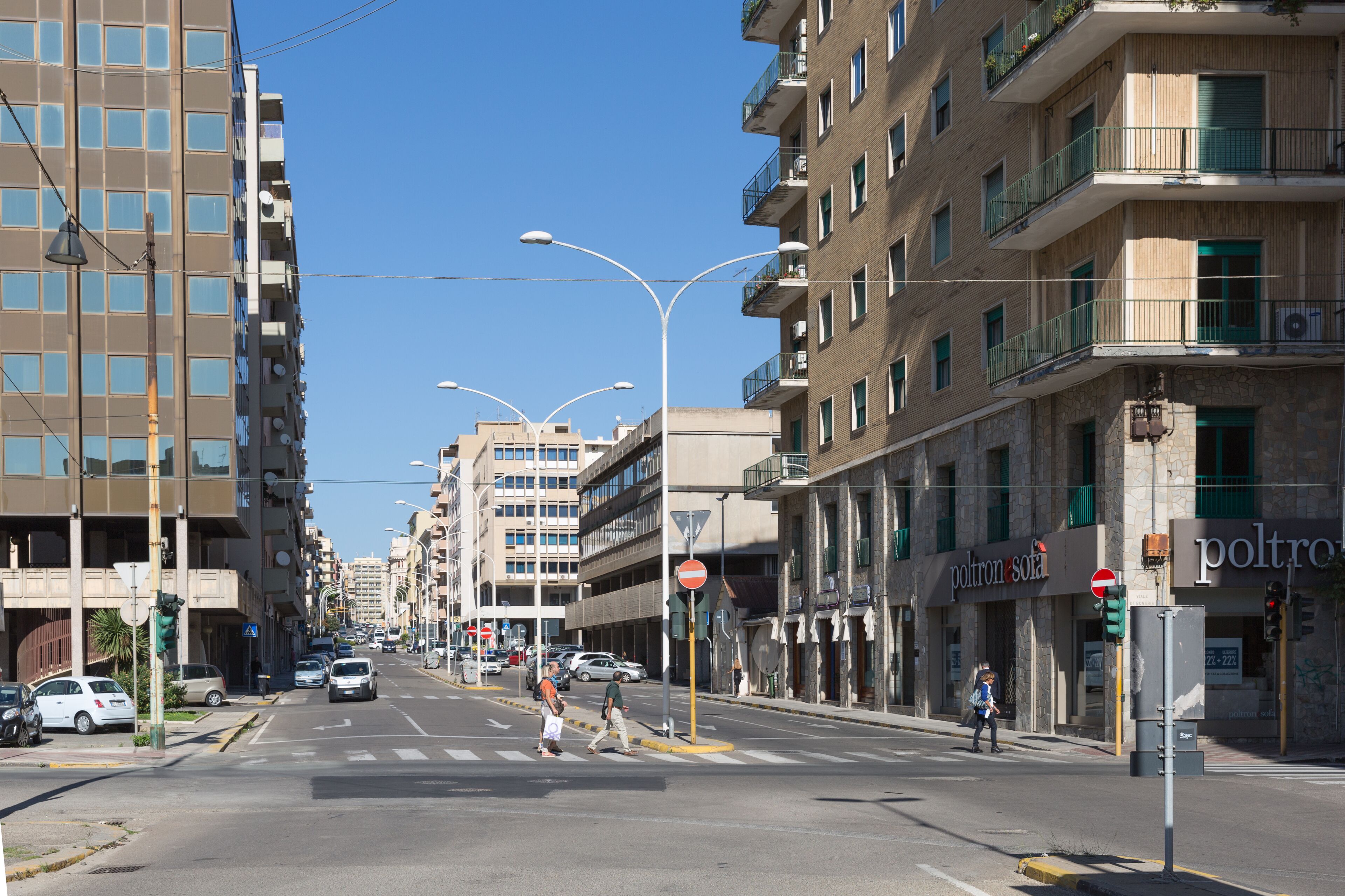 A street view with multi-story buildings, a crosswalk, and a 'no entry' sign.