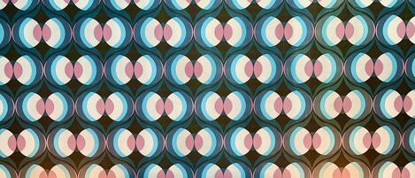 A repeating geometric pattern with circles and lines.