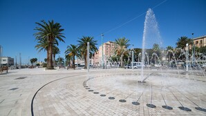 A public square with a central fountain, palm trees, and buildings in the background. - Guest House Sonnino 37 Cagliari (Cagliari)
