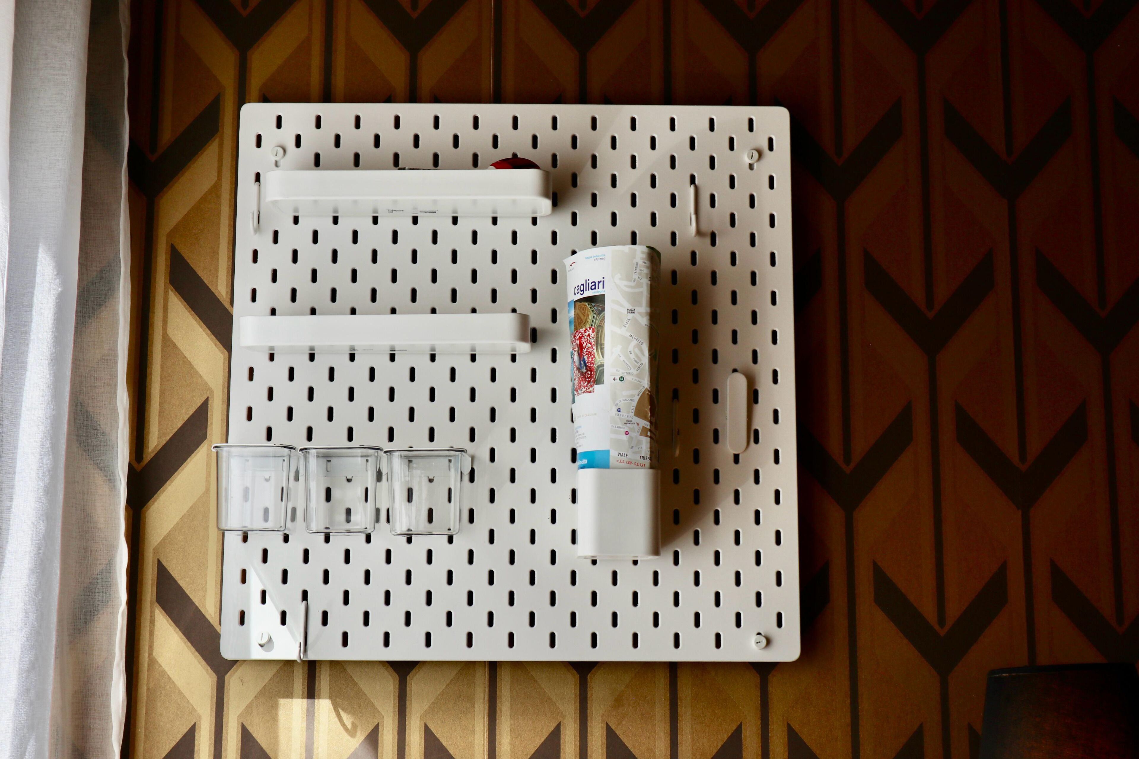 A pegboard wall with hooks and a canister, likely for storage.