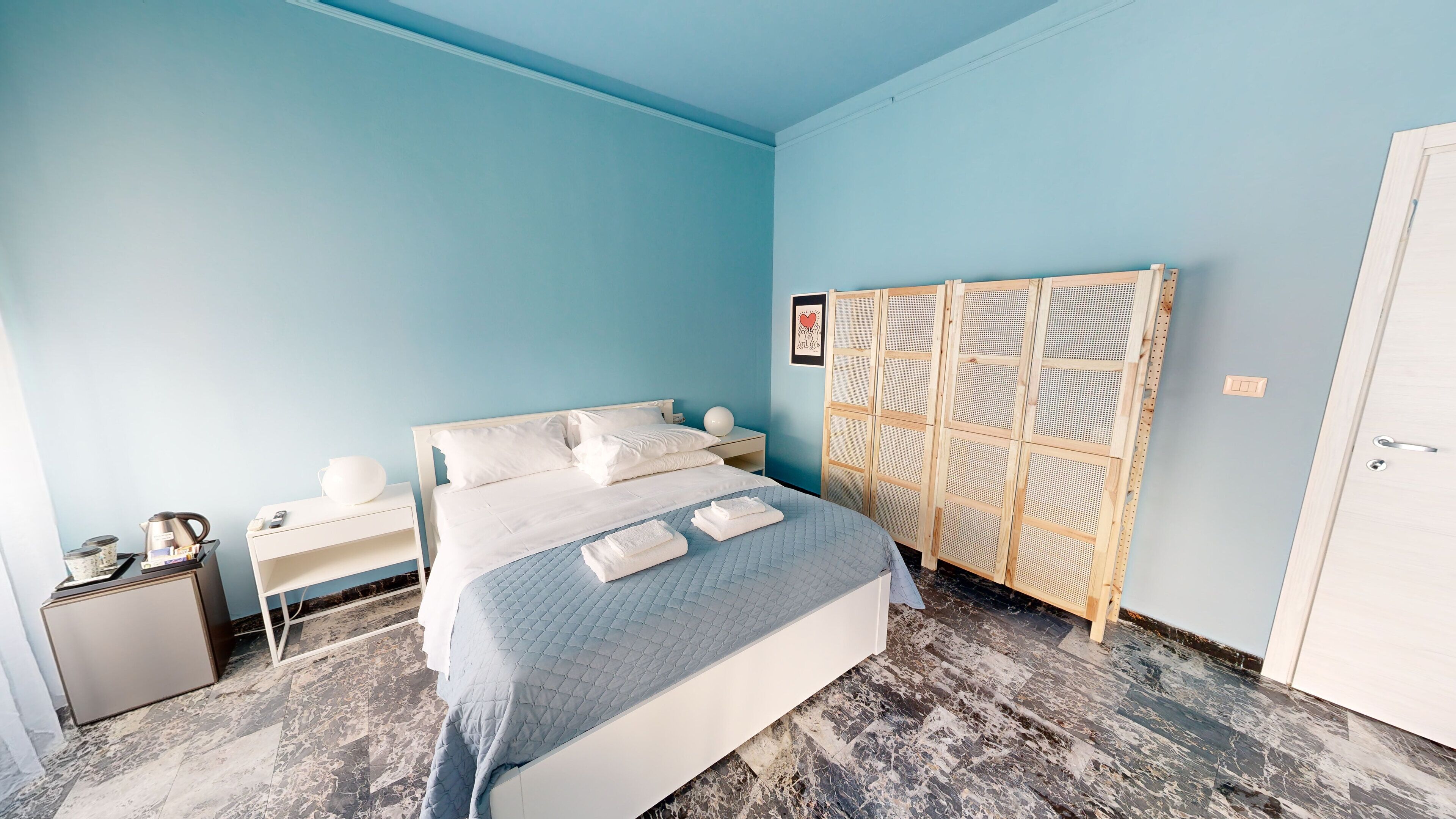 Une chambre à coucher avec un lit, des tables de chevet, une armoire et un sol en marbre.