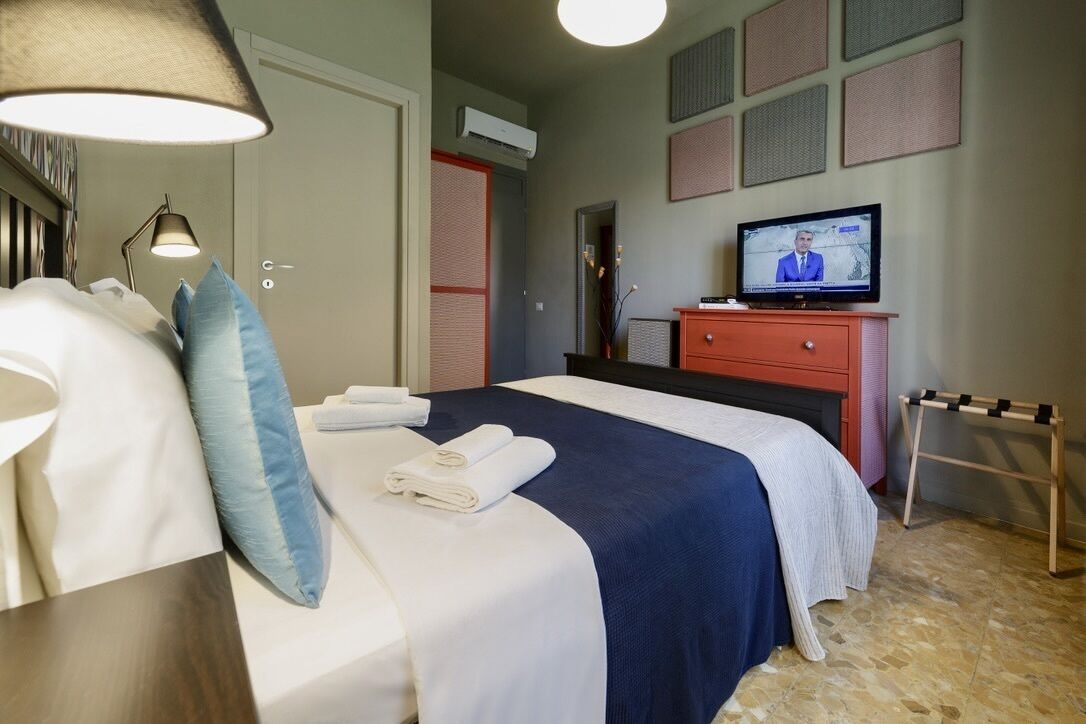 Habitación de hotel con cama, televisión, escritorio y silla.
