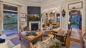 Un salon chaleureux avec une cheminée, des sièges confortables et une vue sur l’extérieur.