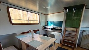 Une cuisine compacte dotée d’une fenêtre, d’un petit réfrigérateur, d’un four à micro-ondes et d’une cuisinière.