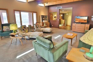 A living room with a sofa, armchairs, a coffee table, and a television. - Desert Paradise at Trails End (Tucson)
