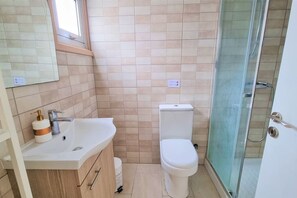 Ein Badezimmer mit Waschbecken, Toilette und Duschkabine.