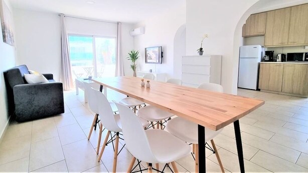 Ein zeitgemäßer Wohnraum mit Essbereich, Küche und einem Balkon mit Blick.