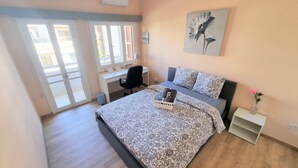 A bedroom with a bed, a desk, a chair, and a window. - The Urban Oasis: Comfort 2br near the City Center! (Larnaca)