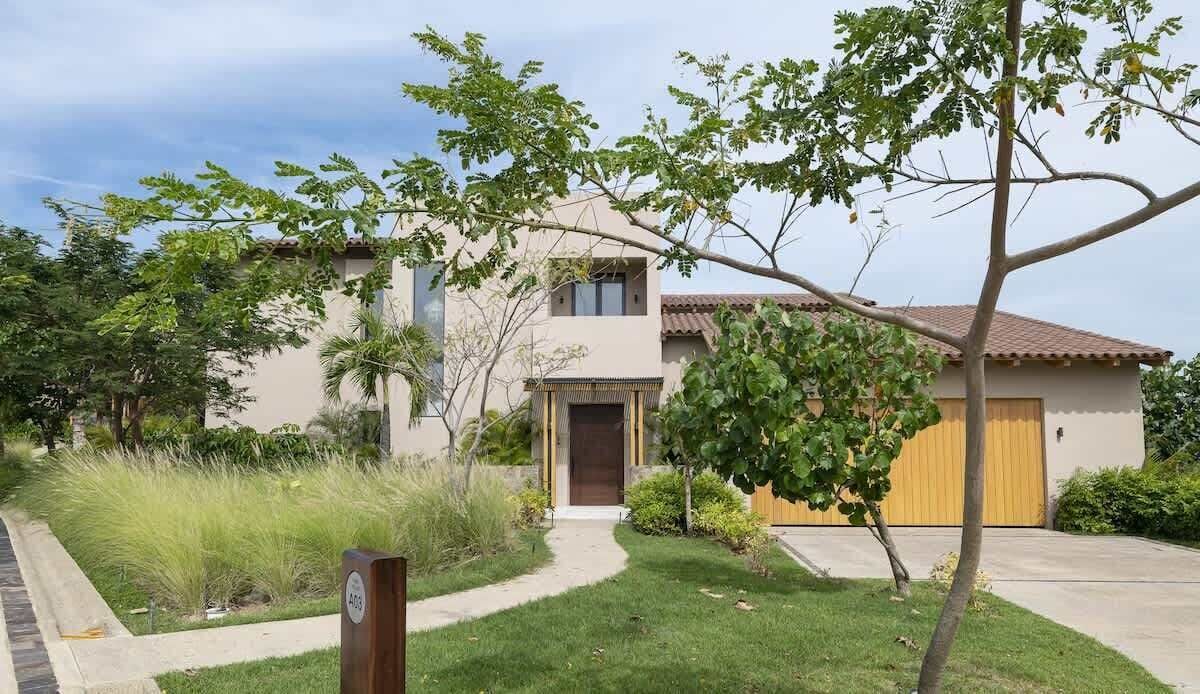 A two-story house with a front door, a garage, and a well-maintained lawn.