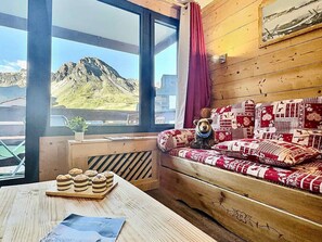 A cozy room with a wooden sofa, a teddy bear, and a table with pastries.