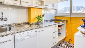 Eine moderne Küche mit weißen Schränken, Granit-Arbeitsplatten und einem eingebauten Geschirrspüler.
