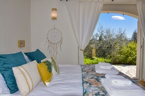 A bedroom with a bed, pillows, a dreamcatcher, and towels. - Villa Provençale Avec Piscine, vue Exceptionnelle Dans un Domaine Privé (MONTAUROUX)
