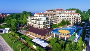 A multi-story hotel with a swimming pool, outdoor seating, and lush landscaping. - PRESTIGE CITY2  (Primorsko)