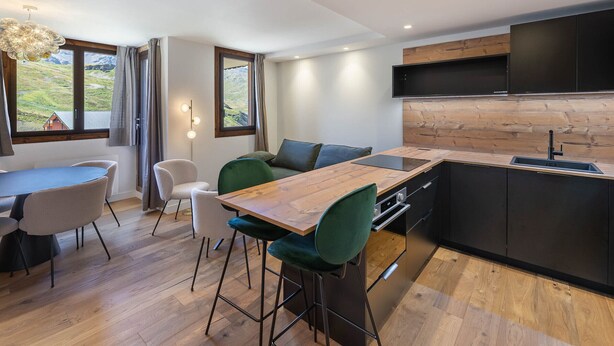 A modern kitchen with a wooden countertop, a built-in oven, and a black sink. - Renovated 2-bedroom apartment in Val Thorens with WiFi (Val Thorens)