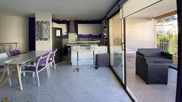 A modern apartment with a kitchen, dining area, and balcony. - Modern T3 in Central Cavalaire - Walk to Beach & Shops, Parking, A/C, Spacious Terrace (Cavalaire-sur-Mer)