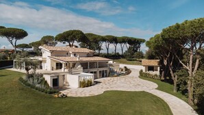 A modern two-story house with a spacious patio and a curved driveway.