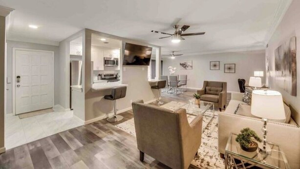 A modern living room with a sofa, armchairs, a coffee table, and a dining area with chairs. - GP46A | G. Prairie Haven | 2BD | Pool | Patio (Grand Prairie)