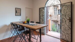 A dining area with a wooden table, black chairs, and a potted plant. - New Charming Studio Unit in the Heart of Trastevere - Studio 1 (Roma)