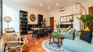 A living room with a sofa, chairs, a coffee table, and a bookshelf. - New Charming Studio Unit in the Heart of Trastevere - Studio 1 (Roma)