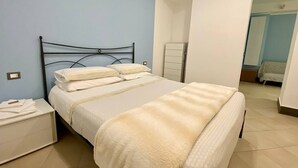 Une chambre à coucher avec un lit, des tables de chevet et une armoire.