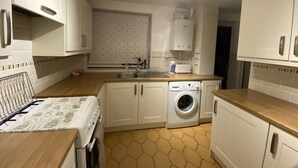 A compact kitchen with white cabinets, a washing machine, a toaster, and a sink. - Serene 3/4BR in Harborne (Harborne)