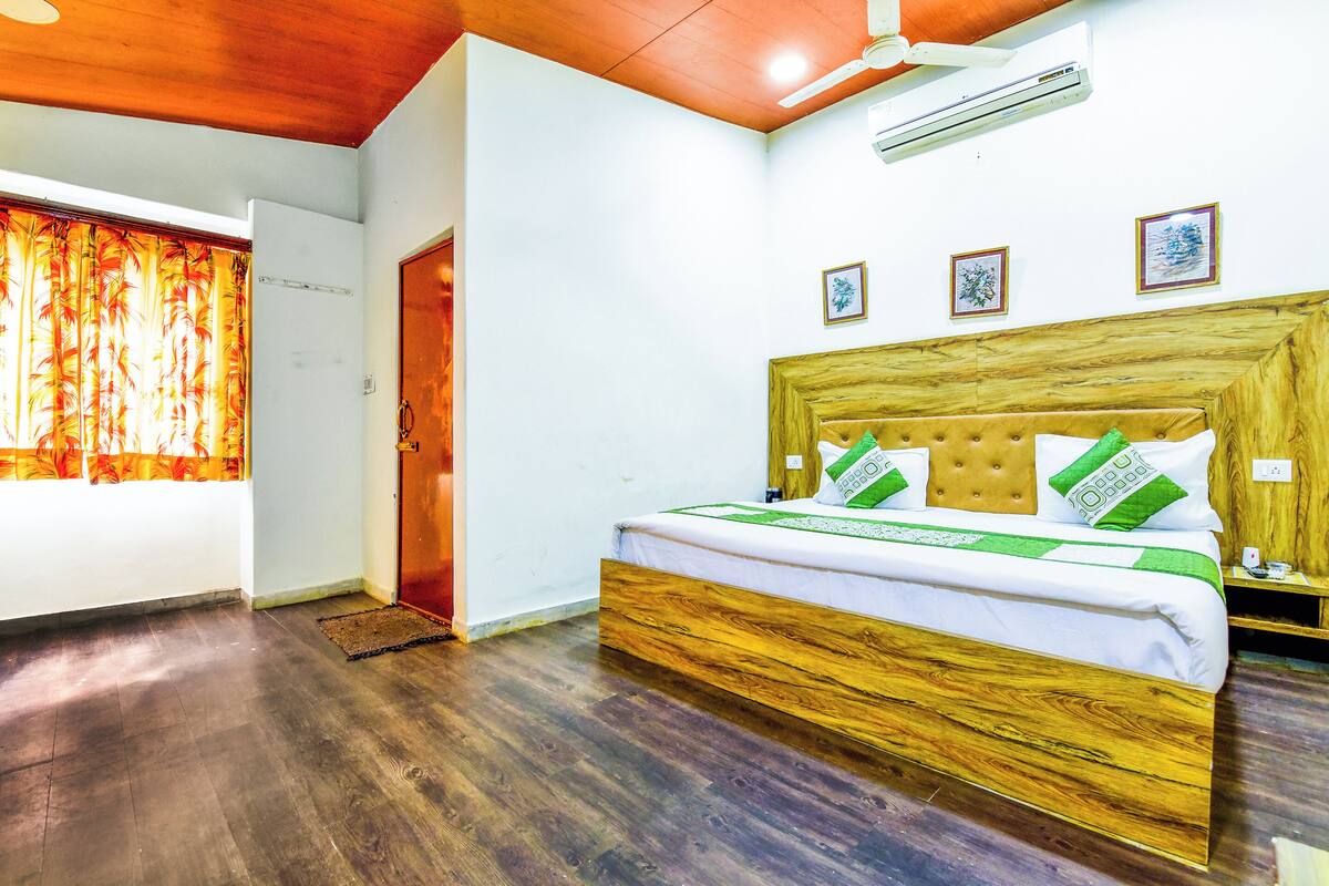Ein Schlafzimmer mit einem hölzernen Bett, weißen Wänden und einem Deckenventilator.