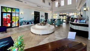 A spacious lobby with a central seating area, large windows, and a reception desk. - Pool Privacy! Value! Resort 6 mi 2 Disney! 1712 (Kissimmee)