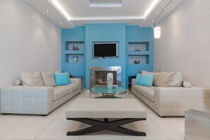 Een smart-tv, een open haard, boeken en een stereo