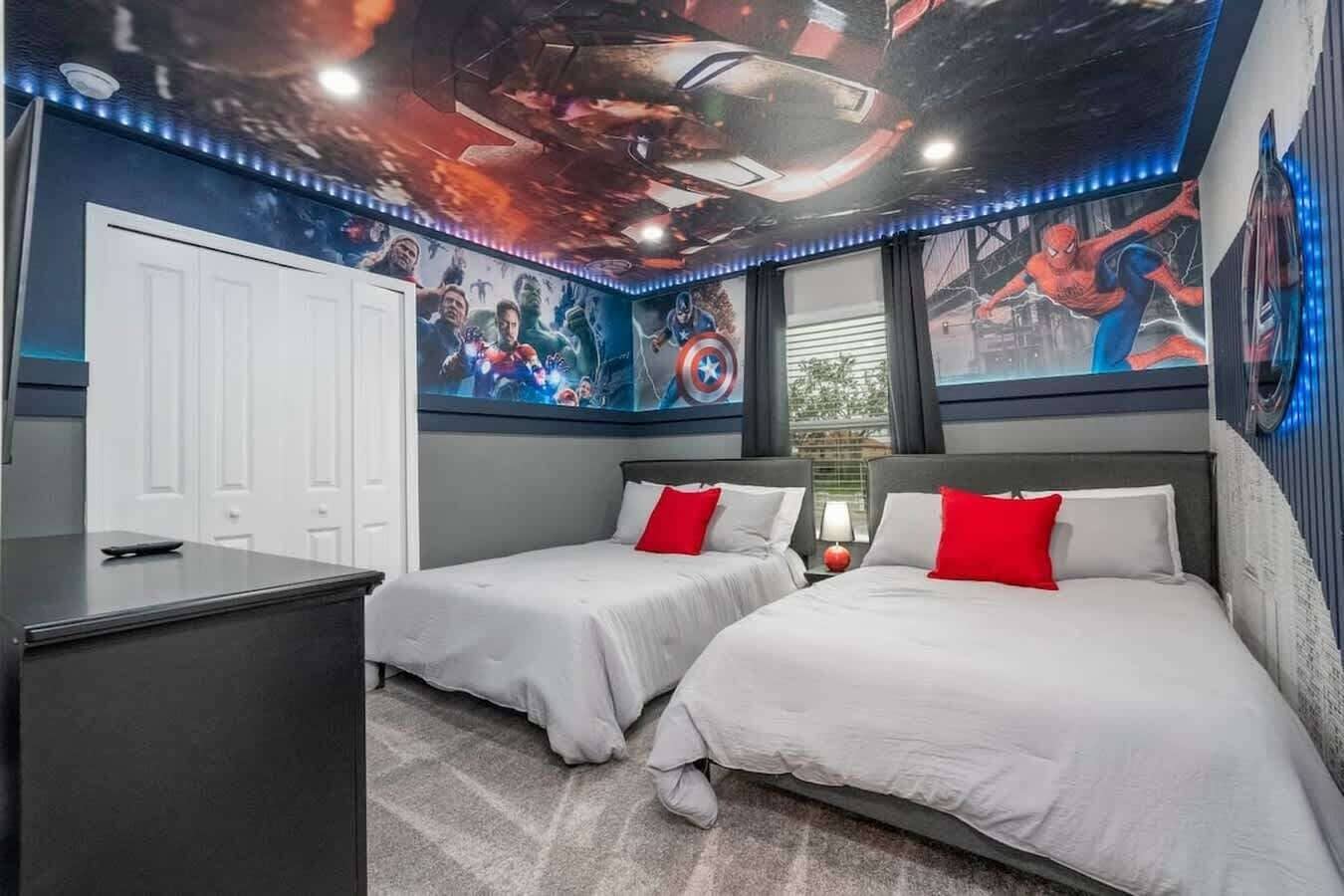 Une chambre avec deux lits, un bureau et une peinture murale au plafond.
