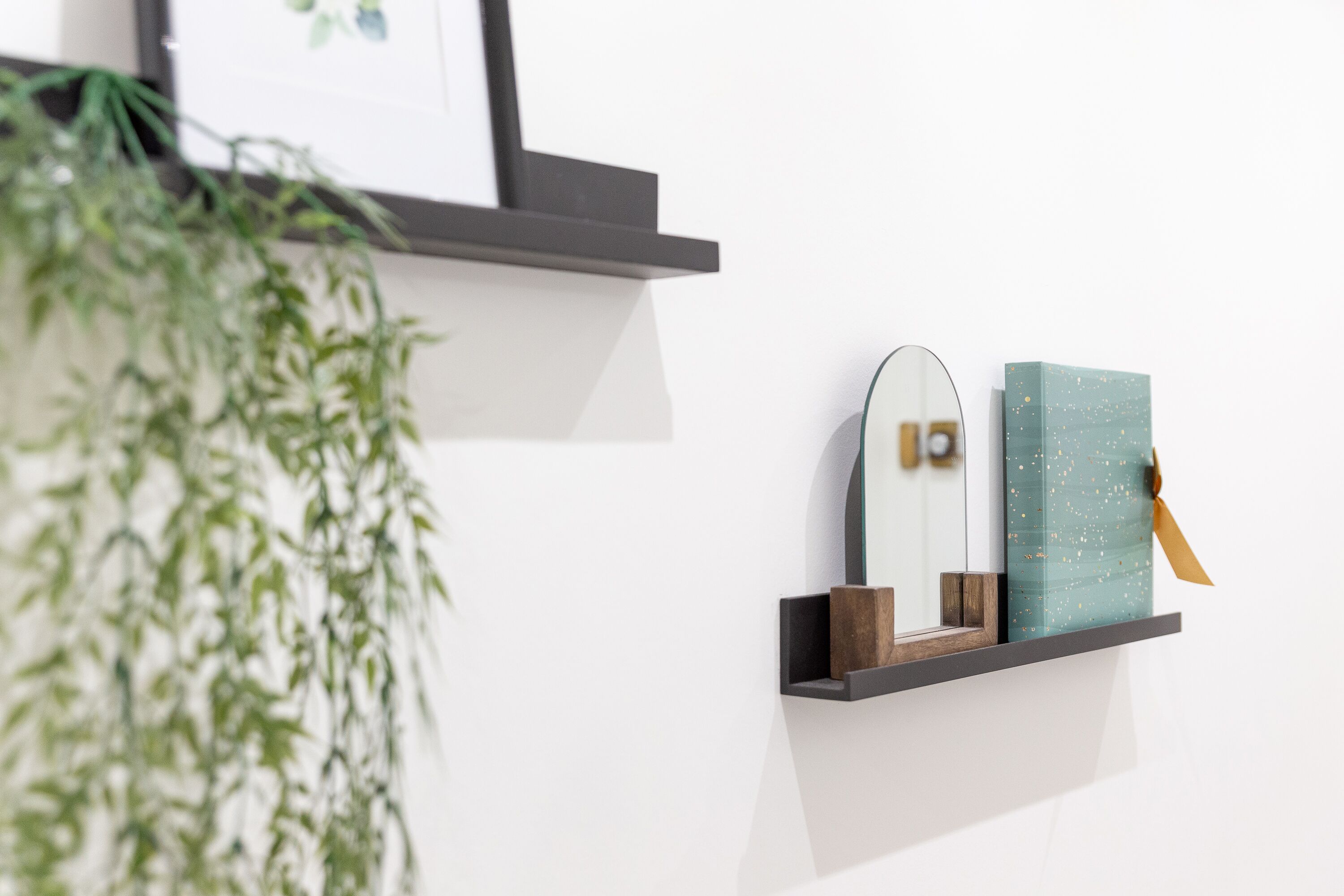 Una repisa con un espejo, una caja decorativa y un bloque de madera.