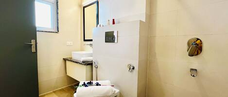 A bathroom with a toilet, sink, and shower.