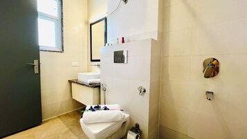 Un baño con inodoro, lavabo y ducha.