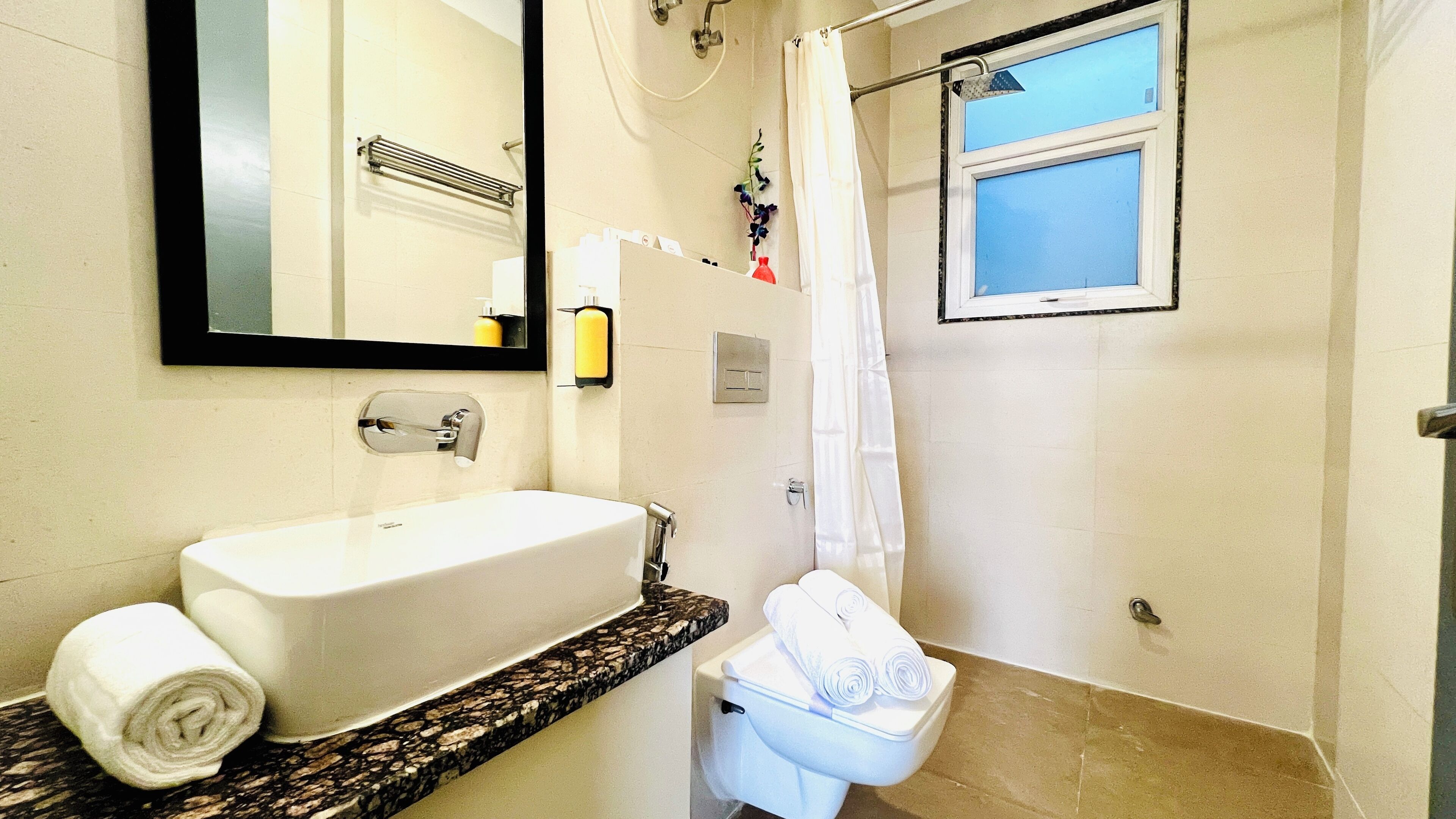 A bathroom with a white sink, a toilet, and a shower.