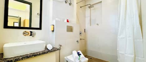 Un baño con lavamanos, inodoro y ducha.