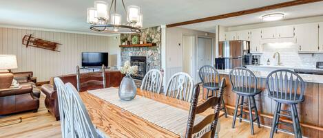 A modern kitchen with white cabinets, a built-in stove, and a large island with bar stools.