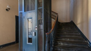A staircase with a metal railing and a door with a security keypad.