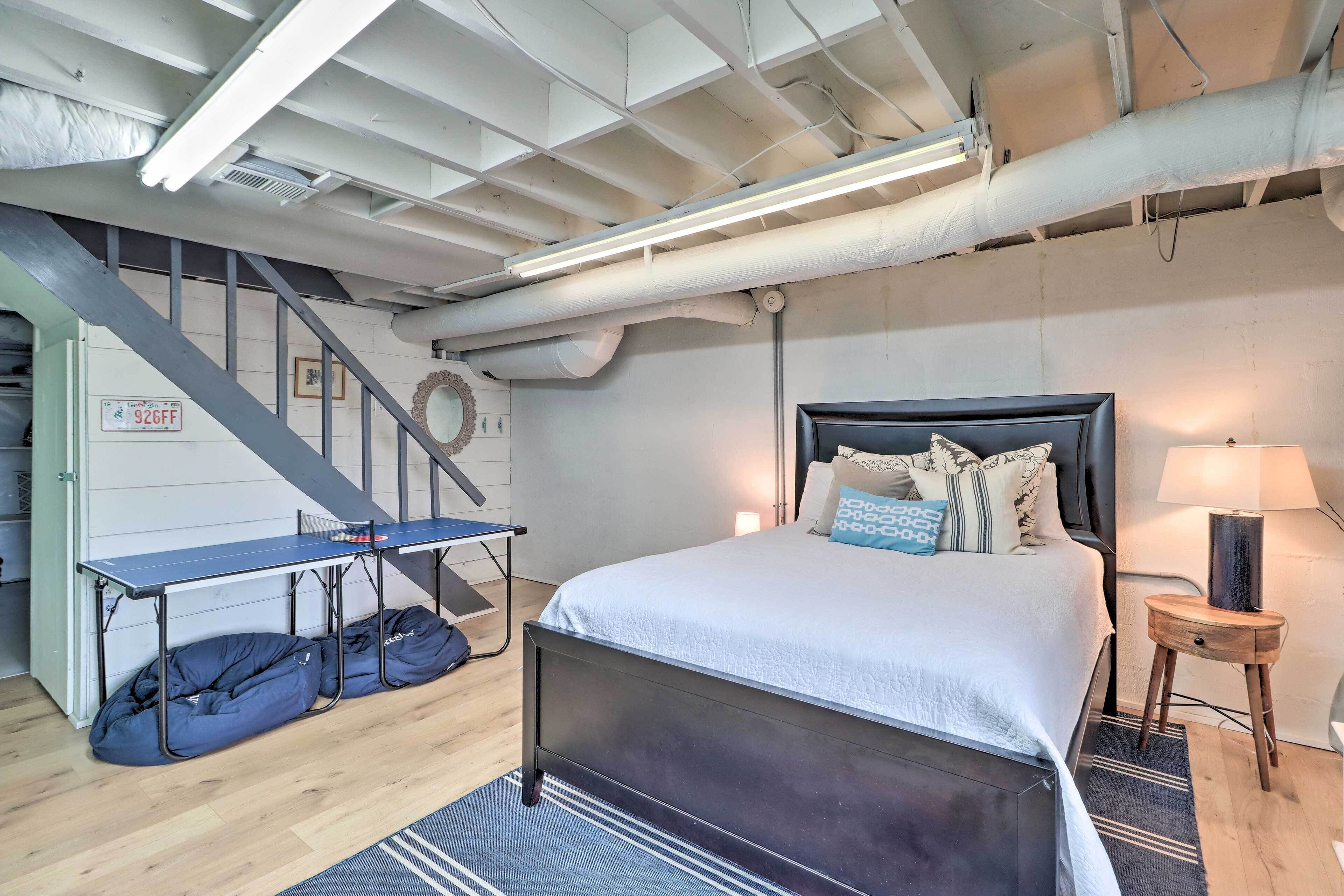 A bedroom with a bed, a desk, and bean bags.