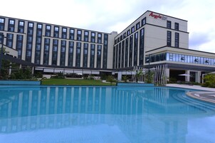 Una piscina al aire libre, sombrillas, sillones reclinables de piscina