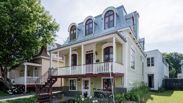A two-story house with a balcony, a front porch, and a staircase leading to the entrance. - Free ferry | Aux Trois Filles (Lévis)