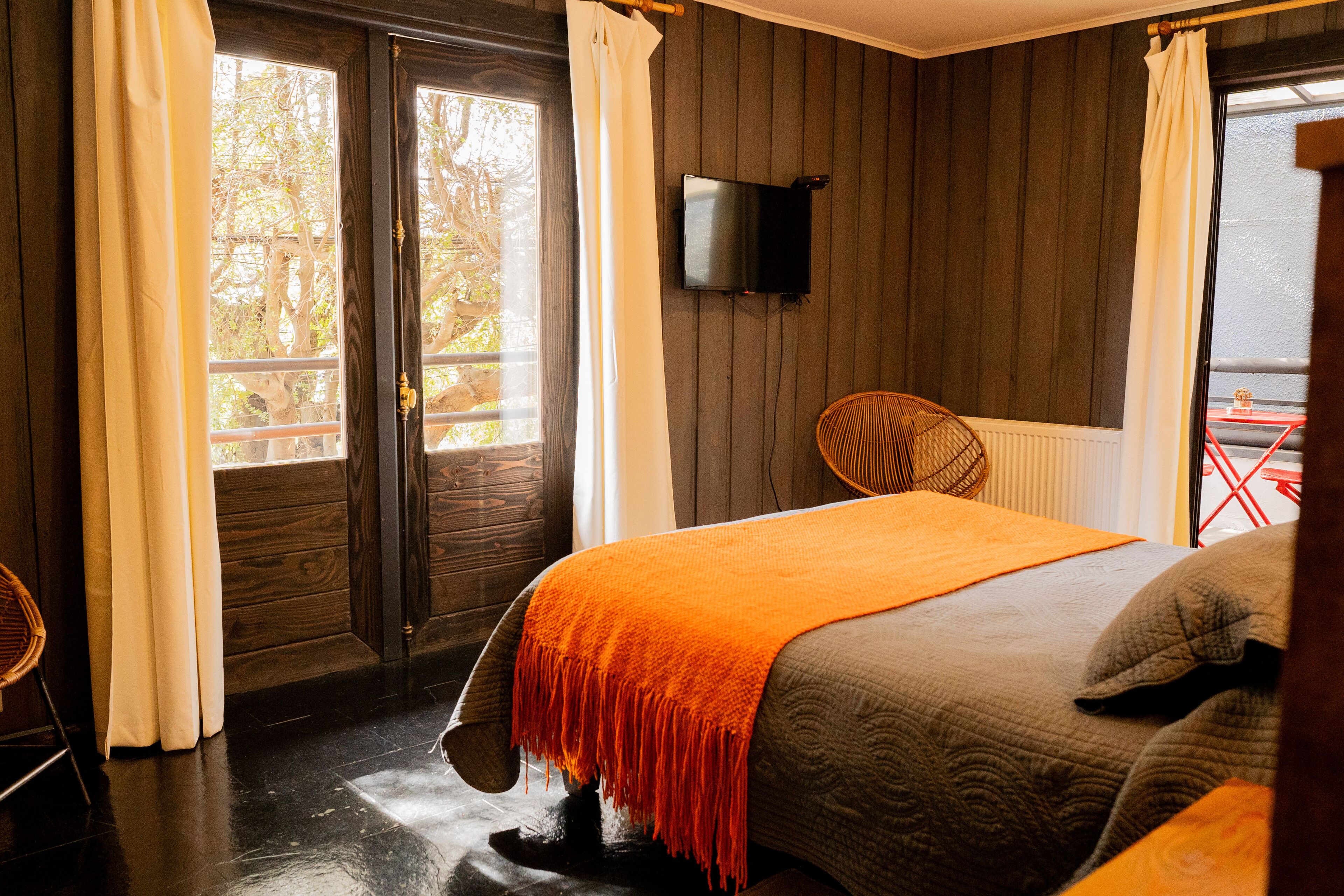 Une chambre à coucher avec un lit, une télévision et une vue sur l’extérieur.