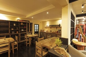 Un restaurante acogedor con mobiliario de madera y una decoración rústica, que incluye una barra y una zona de estar.