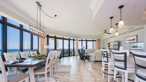 Un grand espace de vie comprenant une grande table à manger, plusieurs chaises, un canapé et un téléviseur.