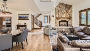 A spacious living area with a dining table, sofas, and a fireplace. - 4418 Columbine Drive 4 Bedroom Home by RedAwning (Vail)