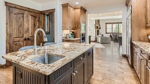 A spacious kitchen with granite countertops, wooden cabinets, and a central island. - 4418 Columbine Drive 4 Bedroom Home by RedAwning (Vail)
